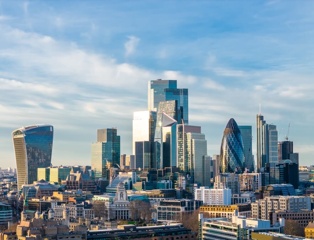 London skyline with the Walkie-Talkie building and The Gherkin against a blue sky, central London.